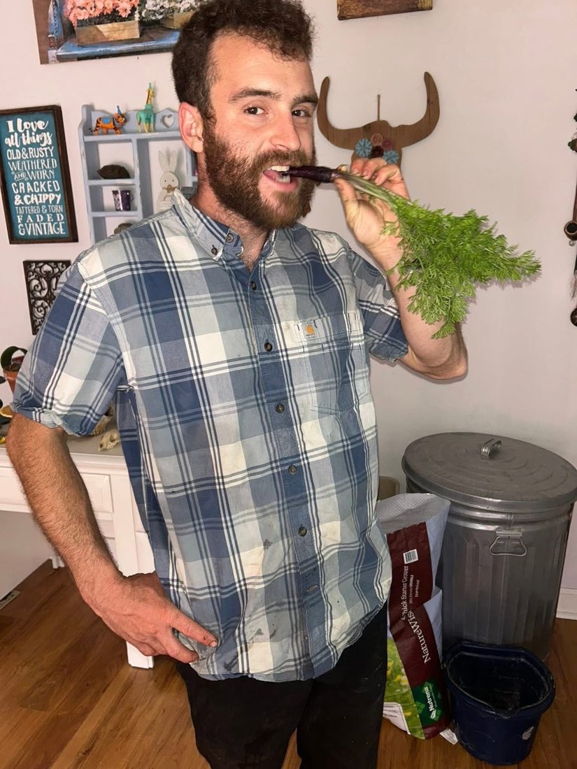 Joseph holding a freshly harvested carrot