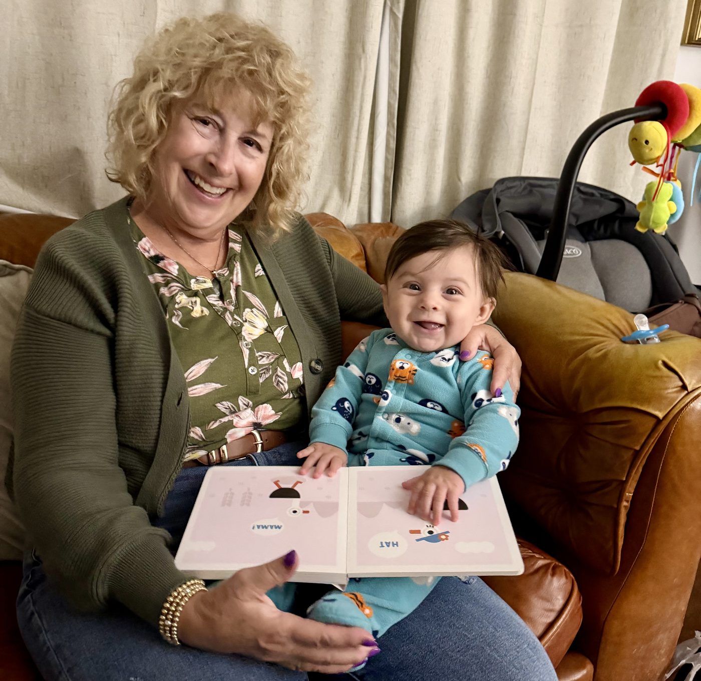 Karen smiling with Charlie and a picture book
